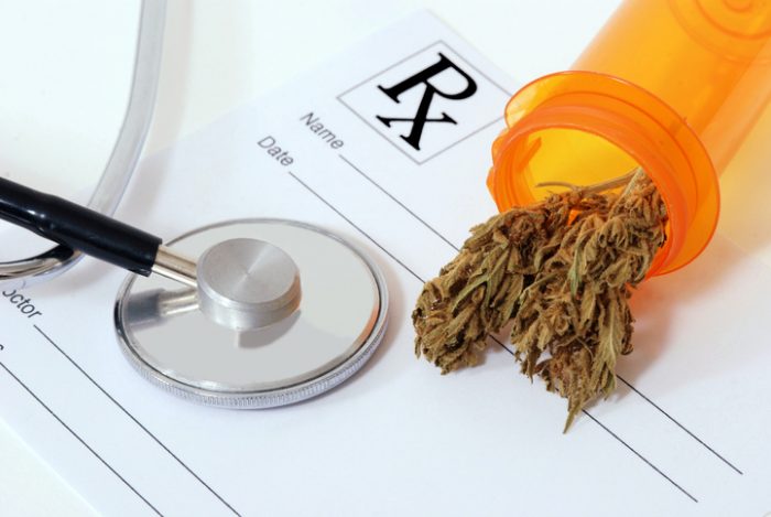 Cannabis bud sitting on a prescription pad, near a stethoscope