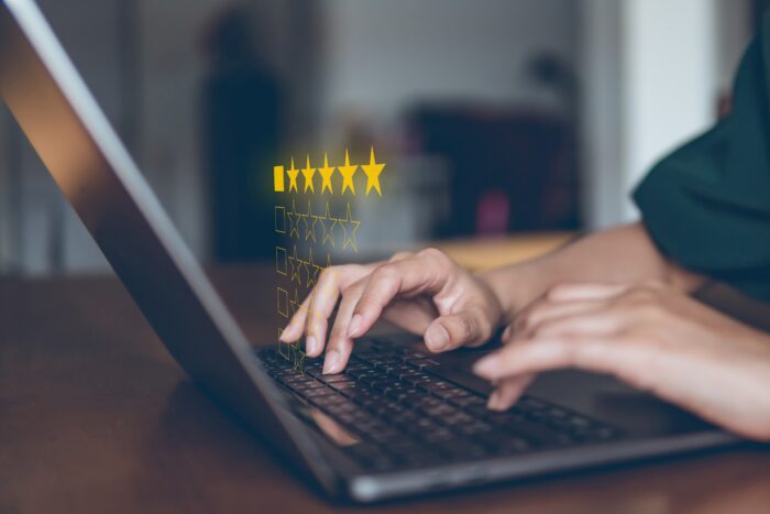 Image of a customer leaving a business 5 stars on a laptop.