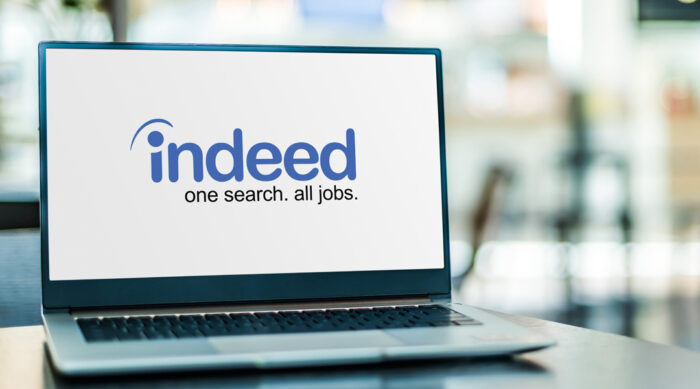 Indeed logo on a white laptop computer screen on an office desk.