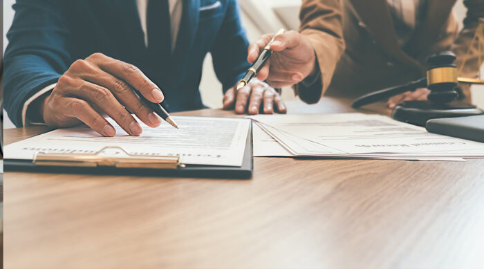 Defamation attorneys review anti-SLAPP statutes at a wooden desk in a law office.