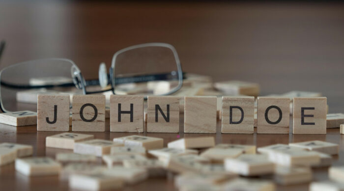 Wooden letters aligned to spell John Doe on a lawyer’s desk.
