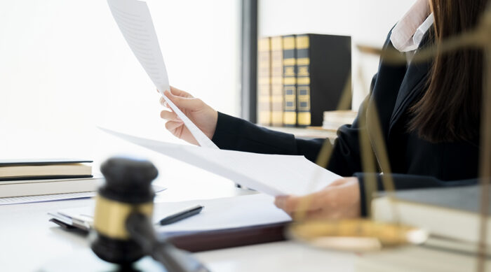 A female defamation attorney reviews documents of a John Doe defamation case.