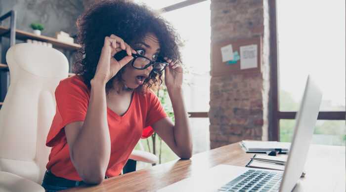 Women with a surprised look on her face after looking at images on a laptop computer.